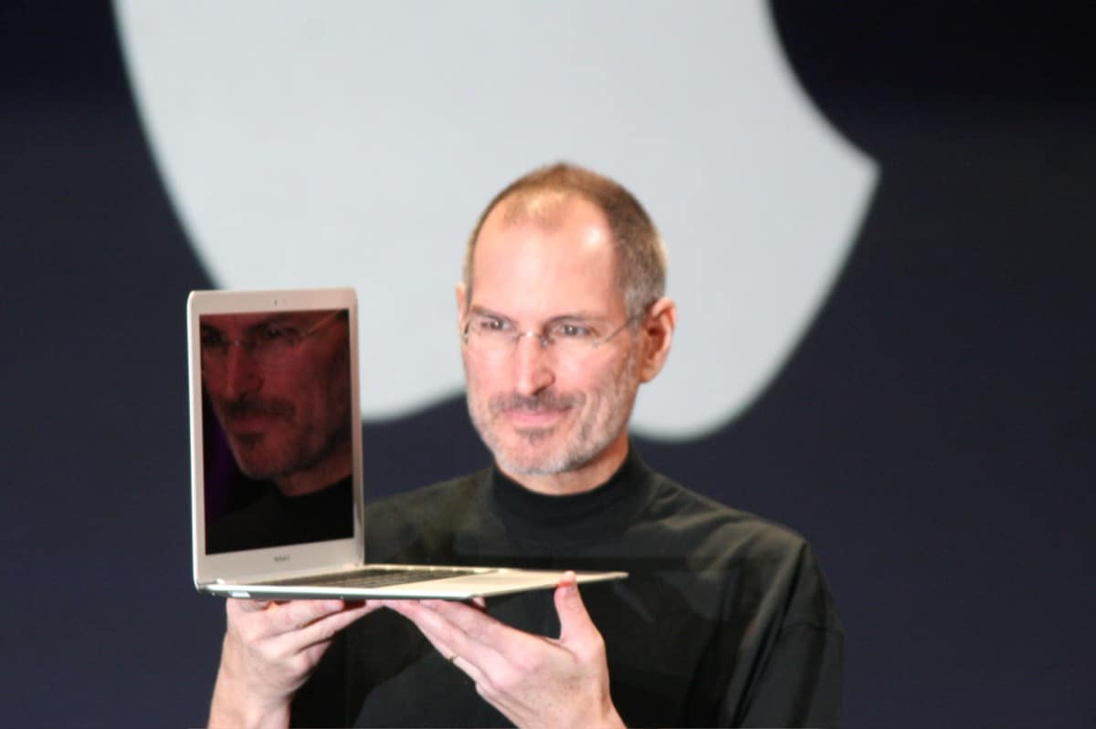 Steve Jobs sosteniendo una computadora